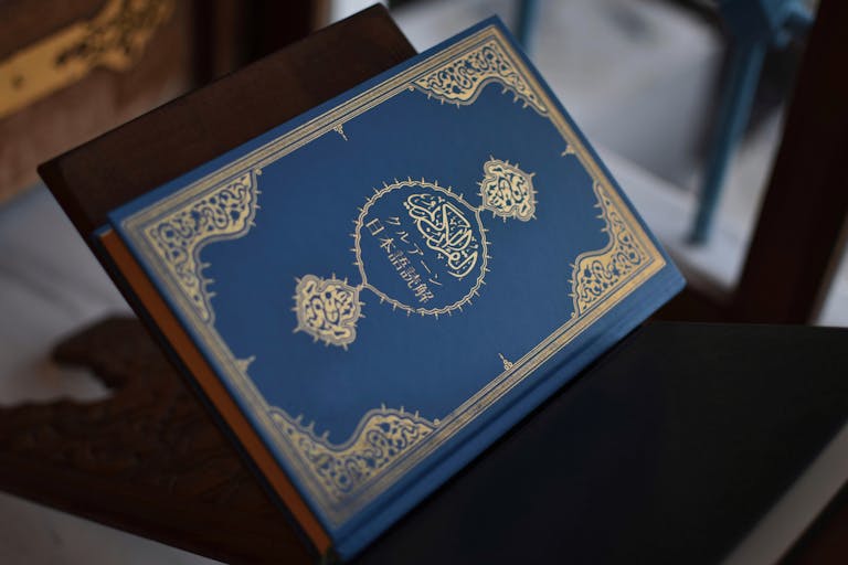 Close-up of a beautifully designed Quran with intricate patterns on a wooden stand.